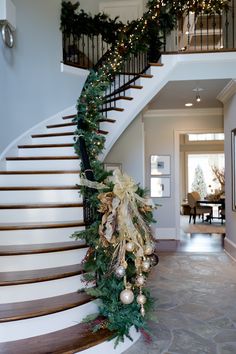 a staircase decorated for christmas with garland and lights