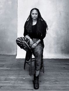 a black and white photo of a woman sitting on a chair