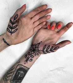 two hands holding each other with tattoos on them