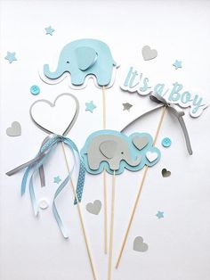 there are two cake toppers with elephants on them, one is blue and the other is gray