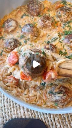 a bowl filled with pasta and meatballs on top of a table