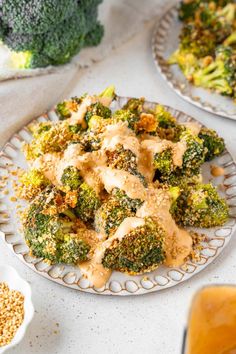 broccoli and other food items on plates with sauce in the middle next to them