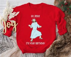 "The Christmas sweater in this collection showcases the same festive message, \"Go Jesus, It's Your Birthday.\" Just below the text, you'll find a delightful illustration of Jesus, donning a Santa hat, and dancing merrily. The combination of religious humor and holiday spirit is captured in this whimsical design. It humorously blends the religious and festive aspects of Christmas, providing a unique and light-hearted way to celebrate the birth of Jesus. It's a perfect choice for those who apprec Kate Bishop Christmas Sweater, Birthday Sweater, Religious Humor, Funny Jesus, Catholic Christmas, Christmas Sweater Funny, Jesus Birthday, Jesus Sweatshirts, Jesus Funny