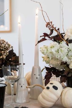 the table is set with candles, pumpkins and other decorative items for halloween dinner