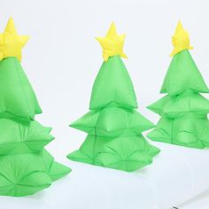 three green christmas trees with yellow stars on top are shown in front of a white background