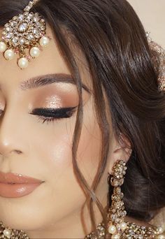 a close up of a woman wearing a bridal outfit with pearls and jewels on her head