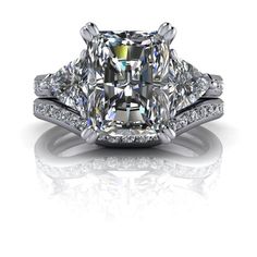 a fancy cushion cut diamond engagement ring with two side stones on the sides and an intricate band