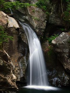 there is a waterfall in the middle of some rocks