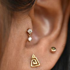 a close up of a person's ear with two different types of piercings