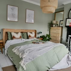 a bedroom with a bed, dressers and pictures hanging on the wall above it