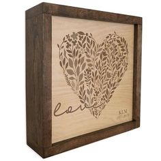 a wooden frame with a heart and leaves on it