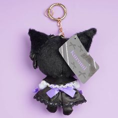 a keychain with a black cat wearing a skirt and purple bow tie on it