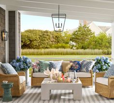 a porch with wicker furniture and blue flowers