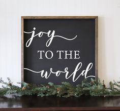 a black and white sign that says joy to the world with pine cones on it