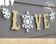 the word love spelled out with snowflakes on a string in gold and white