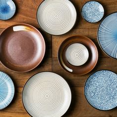 several plates and bowls on a wooden table