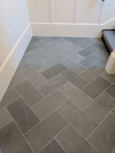 a bathroom with gray tile flooring and white walls