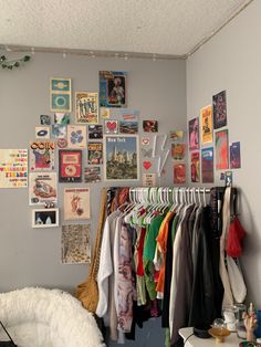 a room with clothes hanging up and pictures on the wall