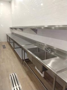 an empty commercial kitchen with stainless steel sinks