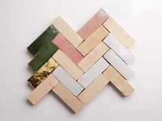 several pieces of wood are arranged together on a white surface, including one green and one pink