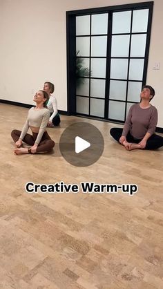 three people are sitting on the floor in yoga poses and one person is standing up