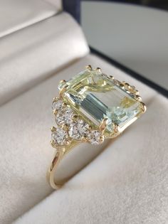 a ring with an aquamarine and white topazte surrounded by small diamond accents