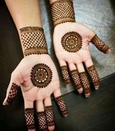 two hands with henna tattoos on them, one is showing off the intricate design