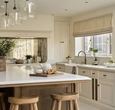 a kitchen island with stools in front of it