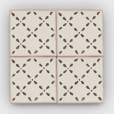 four square tiles with black leaves on them