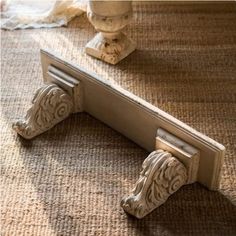 a close up of a door handle on a carpeted floor with a vase in the background