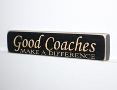 a black and gold sign that says good coaches make a difference on the side of a white wall