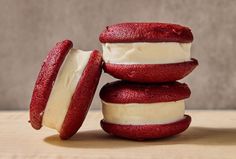 red velvet cookies with white frosting are stacked on top of each other