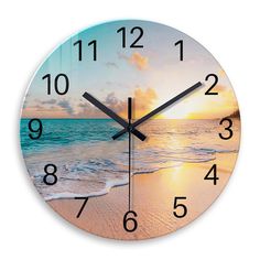 a clock with the sun setting over an ocean and beach scene on it's face