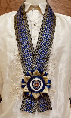 a close up of a person wearing a white shirt and blue ribbon around his neck