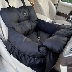 a car seat with a black cover on it and a steering wheel in the back