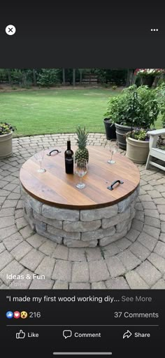 a table with two wine glasses sitting on top of it in the middle of a brick patio