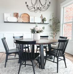 a dining room table with black chairs and a chandelier