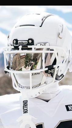 a football helmet with the reflection of buildings in it's visor, is shown