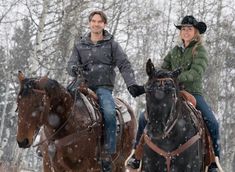 two people are riding horses in the snow