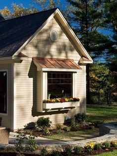 a small white house with flowers in the window