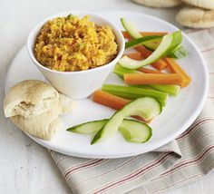 a white plate topped with carrots, celery and other vegetables next to bread