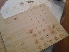 there is a wooden cutting board with holes in the middle and tools on the table