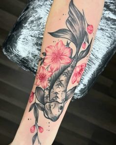 a woman's leg with a koi fish and flowers on it