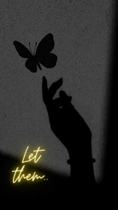 the shadow of a person holding a butterfly in their hand, with text that reads let them