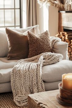 a living room filled with furniture and a fire place covered in blankets next to a window