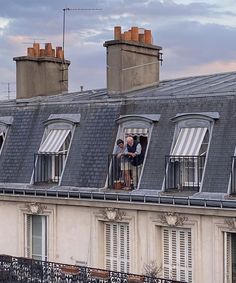 two men standing on the roof of a building