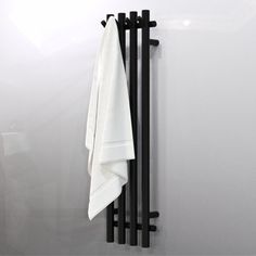 a towel hanging on the side of a white wall next to a black metal rack