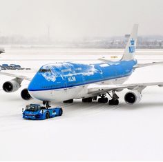 an airplane is parked on the snow covered tarmac