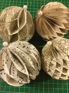 four origami hats with musical notes and pearls on them, sitting on a green cutting board