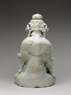 an old white statue sitting on top of a table